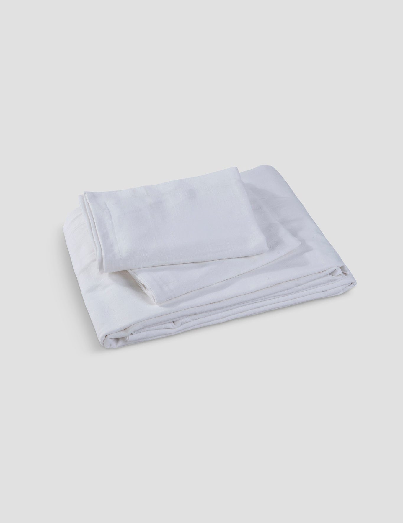 Elysian linen bedsheet set in ivory on a made bed