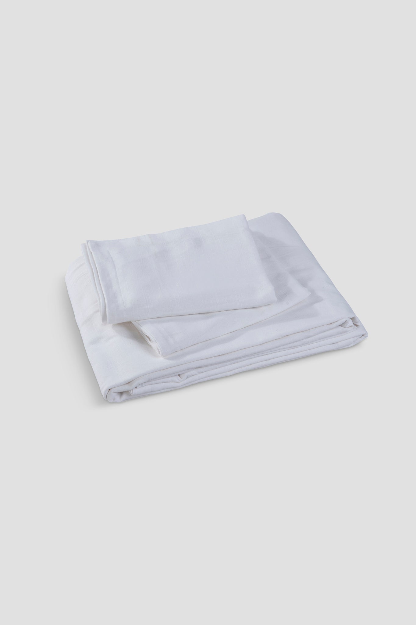 Elysian linen bedsheet set in ivory on a made bed